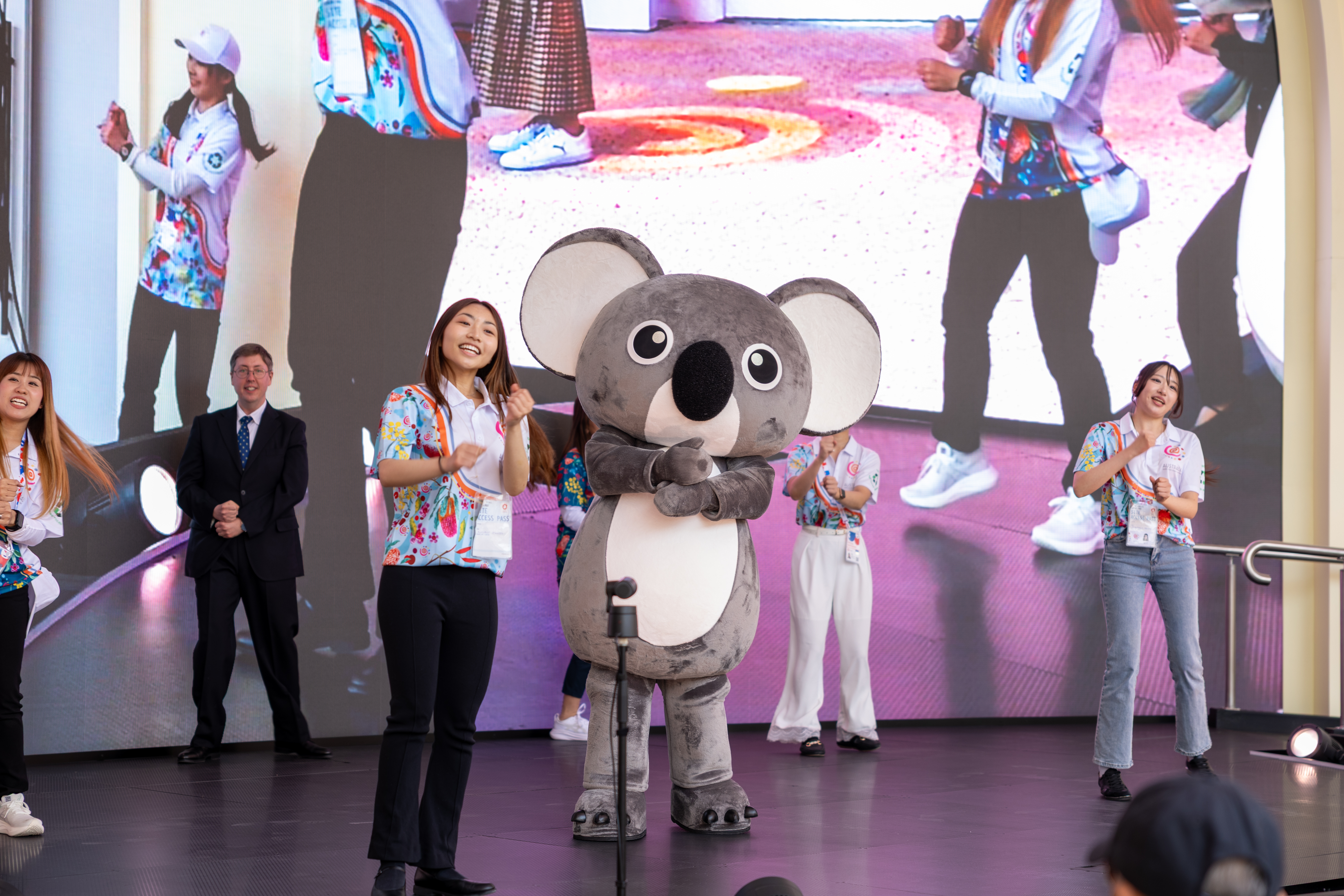 Performance on stage with Koko the Koala mascot and Australia Pavilion staff in uniforms