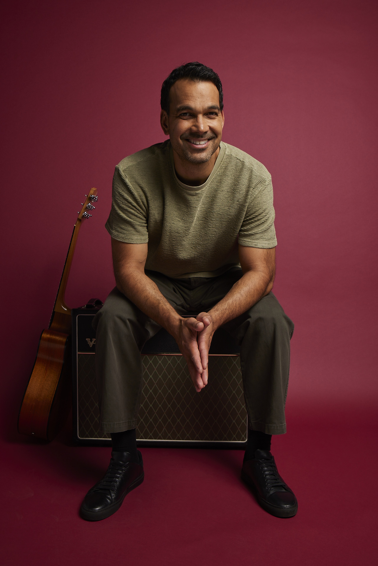 Joel Havea photographed in a studio with a dark red background